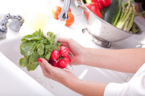 Woman Washing Radish in the Kitchen Sink.